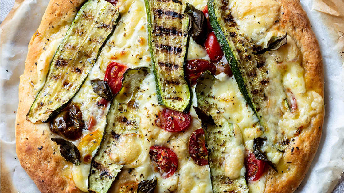 Grilled pizza with olives, mushrooms, and zucchini