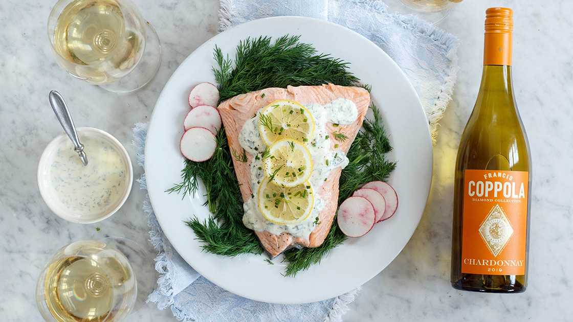 Plate of salmon with herb sauce and chardonnay.
