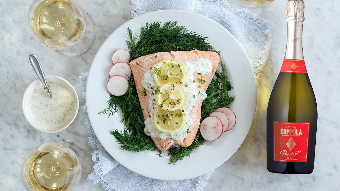 Plate of salmon with herb sauce and Prosecco.